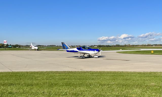 CSA SportCruiser (N145BF) - N145BF, a 2018 CSA SportCruiser, taxing away from the FBO after arriving earlier from Plymouth (C65). The aircraft in the background is N365PF, a 2016 Embraer Phenom 100. 10/23/21. 