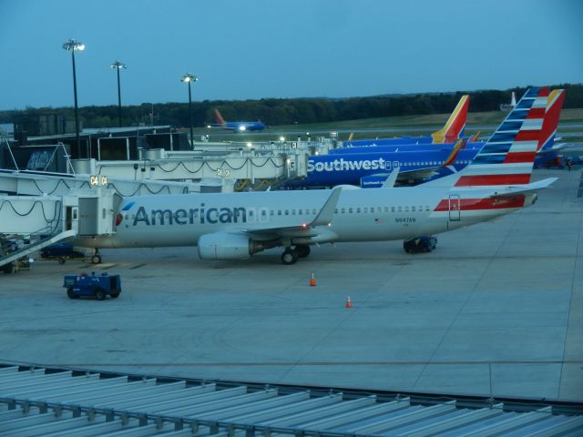 Boeing 737-800 (N947AN) - An American Airlines Boeing B737-800 Sits At The Gate, Next To The AA B737-800 Is A Mix Of Southwest Boeing B737 -700s and -800s, In The Distance Is A B737-700 Landing