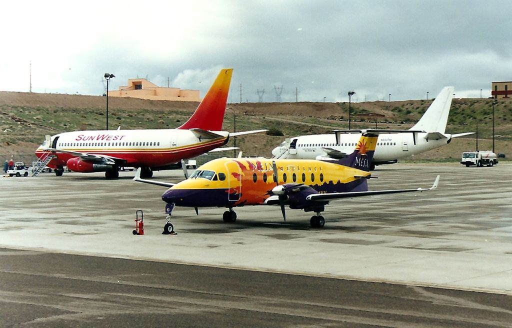 Boeing 737-200 (N705S) - KIFP - busy ramp at Laughlin - The Sunwest 737 is getting ready to head to ATL on a return Gamblers special. Mesa was running KIFP-KPHX on this cool rainy March 2001 view. There is a new terminal now at Laughlin, behind where the 737 jets were parked in this older view.