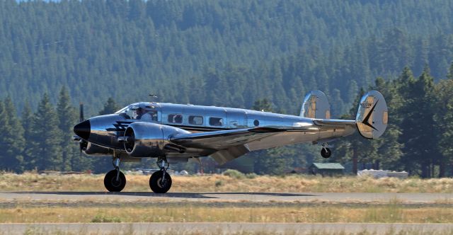 Beechcraft 18 (N3532B) - N3532B, a highly-polished all-silver 1954 Beech D18S, is down and rolling on KTRK's runway 29 as it arrives to be placed on static display at the 2022 Truckee Tahoe Airport Air Show and Family Fest on Saturday, 23 July.br /This one was so highly polished that it reflected EVERYTHING: the sky, the trees, the grass on the ground, and even one of the large white tents on the airport ramp. Fortunately, the sun was not yet directly high overhead so I was able to get a decent capture as it landed. Just three hours later, the temp on the asphalt ramp at TRK was 123 F. It was HOT!! (The kids didn't seem to notice at all, but the adults sure did. lol)