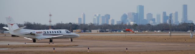 Cessna Citation V (N40HT) - N40HT taxiing at Houston Hobby with the downtown Houston skyline in the background.  Hook em!