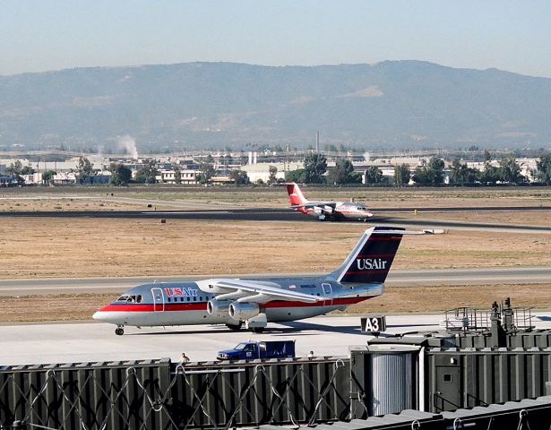 British Aerospace BAe-146-200 (N185US) - KSJC - N185US(foreground) set to taxi to 30L as N163US turns off 30L at San Jose in this early 1990s photo at San Jose,CA.br /br /Serial number 2045 LN:45br /Type Bae 146-200br /First flight date 24/10/1985