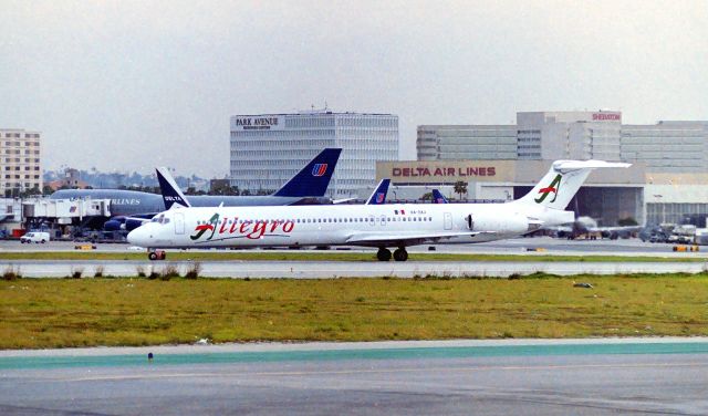 McDonnell Douglas MD-83 (XA-SXJ) - KLAX - early 1990s at Imperial Terminal - Allegro MD-83 landed 25L and slow taxi off the Runway awaiting instructions to cross 25R. The Imperial Terminal Parking lot was a top location to film at Los Angeles - I sure wish digital cameras were readily available back then.