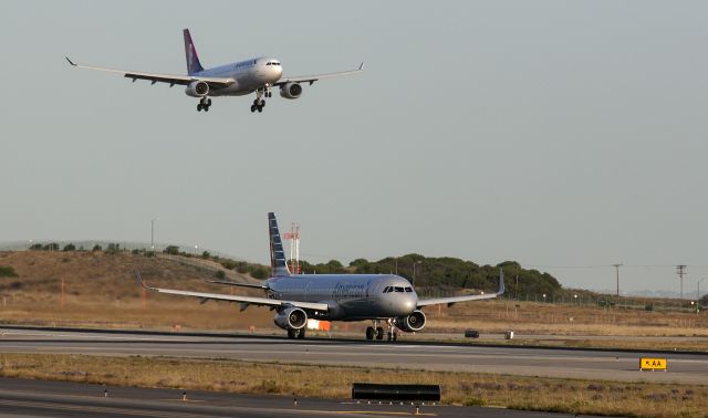 Airbus A330-300 (N392HA) - The Hawaiian Airbus A330 is landing at LAX as an American Airlines A321 begins its take off roll. 