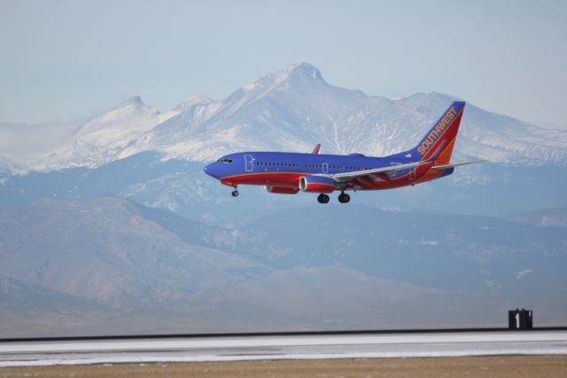 Boeing 737-700 (N7738A) - Landing on 16R at DIA with Longs Peak in the background.