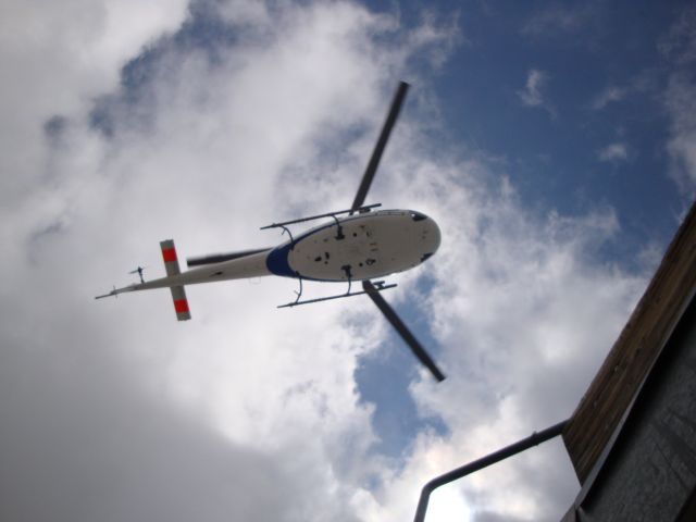 — — - A search and rescue helicopter approaches our hut after retrieving some injured and stuck climbers on Mont Blanc.