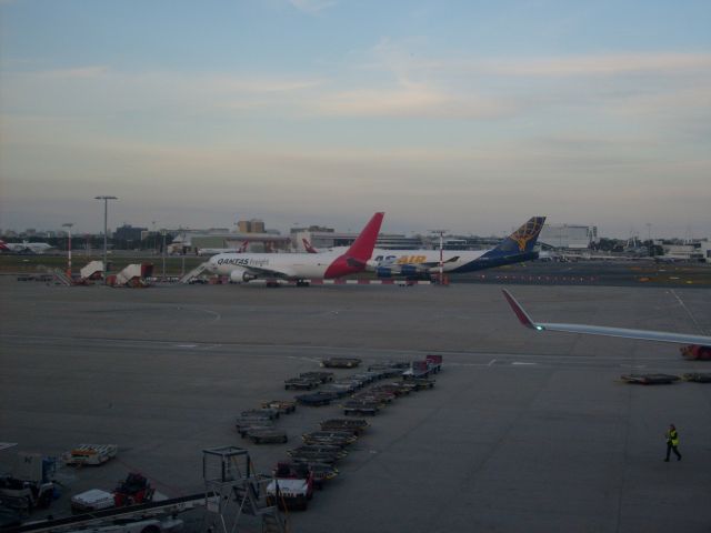 BOEING 767-300 (VH-EFR) - VH-EFR being passed by an Atlas 747-400F at Syndey with empty container trailers in the foreground.