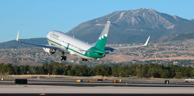 Boeing 737-800 (N916NN) - Americans N916NN, painted in the livery that commemorates the former Reno Air, lifts away from Reno Tahoe Internationals runway 16R and, as it does, it is caught here passing in front of one of the three mountains depicted on the tail.  