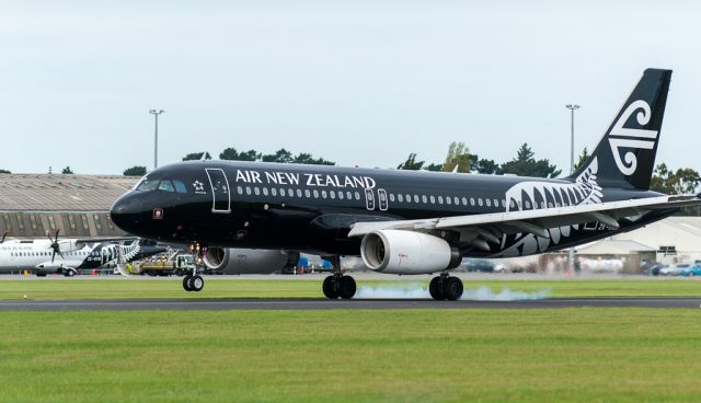 Airbus A320 (ZK-OAD) - ZK-OAB's touch with terra firms spins the rubber up as it lands on Runway 29 in a moderate Nor-west wind. Taken with my Nikon AFS 300mm/f2.8 lens