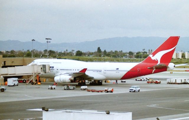 Boeing 747-400 (VH-OJO) - KLAX - January 1996 from the parking garage near the TBT - (now this view blocked). QANTAS 747-4 at the Intl Terminal before being towed off to the remote slot. Delv May 1992 as "Toowoomba" CN: 25544 LN" 894. Repainted years later in July 2011 in the "Wallabies" c/s.