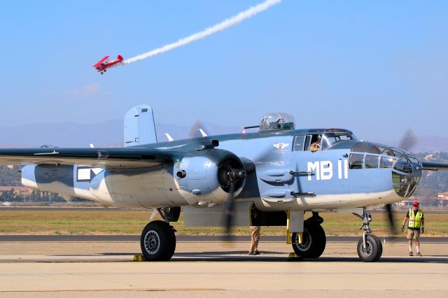 North American TB-25 Mitchell (N5865V) - The Commemorative Air Force SoCal Wing's PBJ-1J, a variant of the B-25J Mitchell utilized by the USMC and USN during World War II, runs up its engines while a PT-17 Stearman flies overhead.