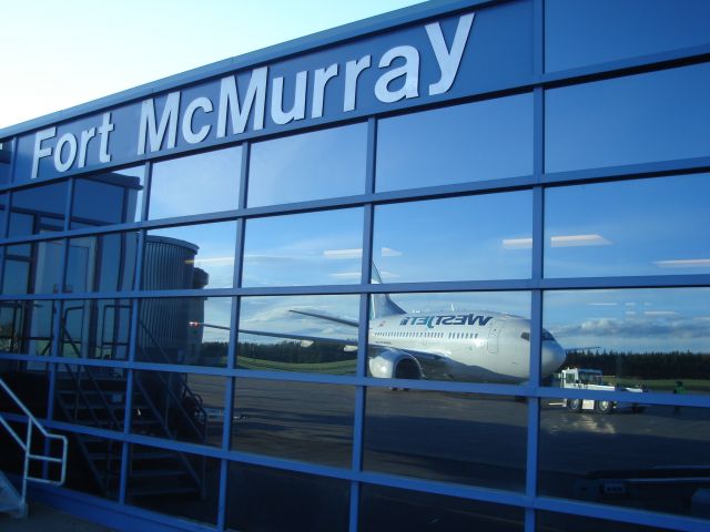 BOEING 737-600 — - Reflection of a WestJet Boeing 737-600 on the terminal at Fort McMurray, Alberta, Canada, May 9th, 2007.