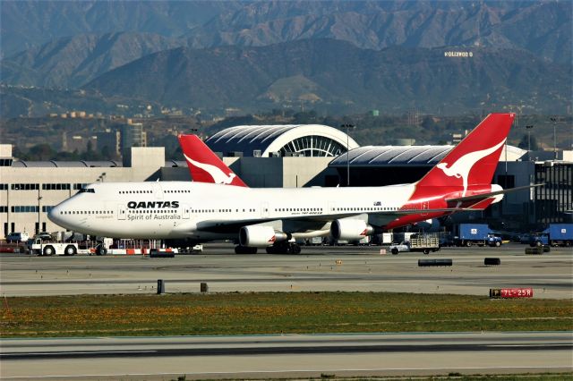 Boeing 747-400 (VH-OEF) - KLAX - "Hooray for Hollywood" I think this was July 2004 down in LA for the Airliners International Collectible show, filming from Imperial Hill this rare clear day made it easy to see the 'Hollywood" sign....in the 1970s down for my 1st trip to Disneyland in Anaheim w/my then girlfriend, we drove up above the Hollywood sign area and just left of the sign there was a flat parking lot where we could look out over the entire LA basin, quite the light show. QANTAS 747-400 shown here being towed to remote adjacent to Runway 25R at Los Angeles. LN 131 now stored as of Feb 2020.