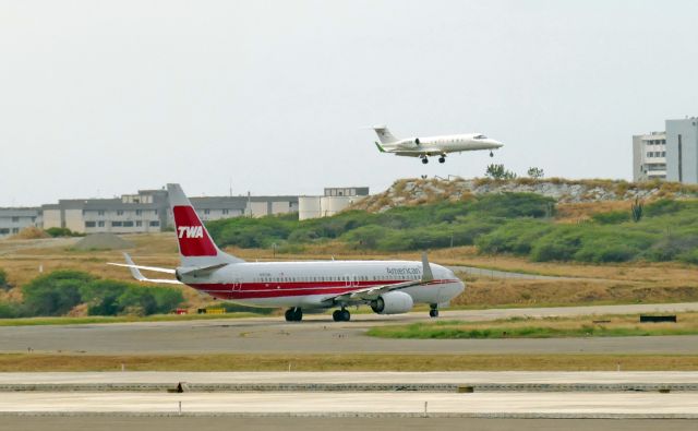 Boeing 737-800 (N915NN) - B737 holding short as Lear 45 YV-2738 lands on Rwy 10.