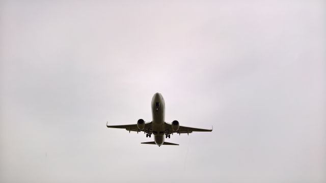 Boeing 737-800 (9Y-BGI) - Seconds from landing on Runway 10 on a rainy day with some light winds 