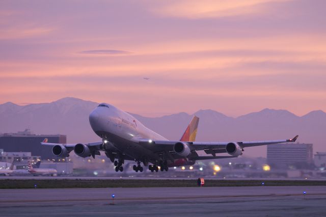 Boeing 747-400 (HL7415) - This big cargo plane is part of the Kumho Asiana Group. It is making a dawn departure from Runway 25L LAX into a sky that is best remembered in the mind. Snow is visible in the distant mountains. A QANTAS 747 just visible in the upper center is on a long downwind for 24R at LAX. 