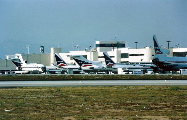 Boeing 737-200 (N237WA) - KLAX- early 1990 view of the Delta docks at LAX. The only jet I can get a reg from is the 737 between the 727 s. I like the view of the far L 727 as it is backed out for taxi. Nice mix of Delta aircraft in this view.