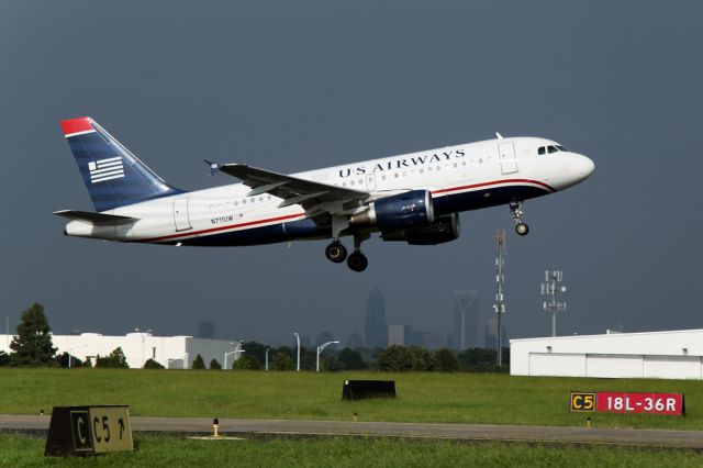 Airbus A319 (N711UW) - A smooth takeoff after a rain shower, downtown Charlotte visible in the distance.