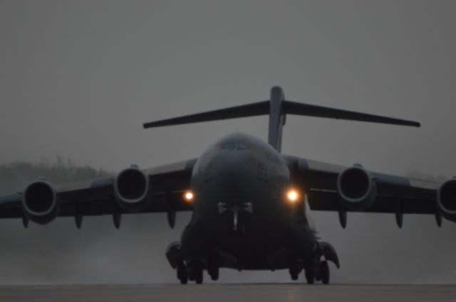 — — - C-17 departing in the rain.