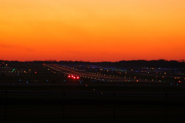 — — - this is a sunset shot of runway 27 at KCVG