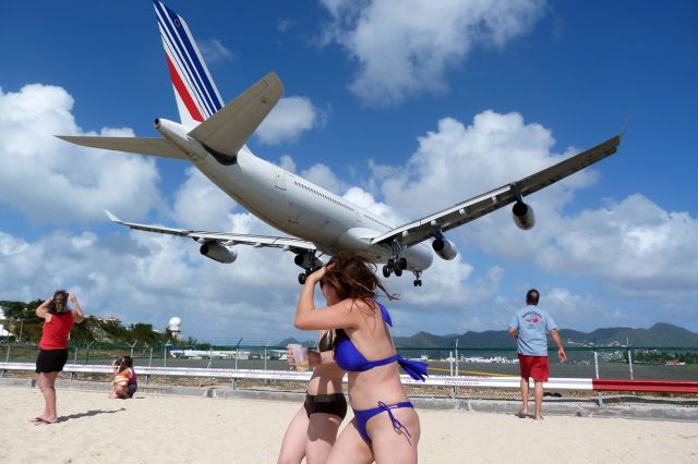 Airbus A340-300 (F-GLZT) - There is a bad and good in St. Maarten. The bad is that someone always manages to randomly step in your picture. The good part is that if this someone (or someones) are two half drunk girls just happening to get a nice experience of an A340 passing 20ft over their heads