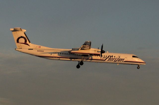 N406QX — - Tinted to a golden yellow hue by the final moments of the setting sun over northern Nevada, this Dash 8 approaches Reno Tahoe Internationals 16R.