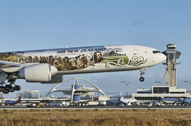 Boeing 777-200 (ZK-OKP) - An Air New Zealand operated Boeing 777-319(ER) widebody jet in special "The Hobbit" promotional livery, about to touch the tarmac at the Los Angeles International Airport, LAX, in Westchester, Los Angeles, California. In the background the iconic Theme Building, near center, and the flight control tower to the right