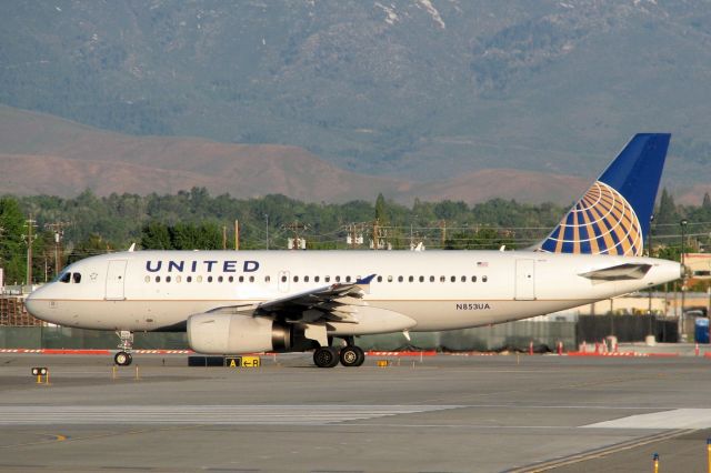 Airbus A319 (N853UA) - Positioned to begin its departure roll down runway 16R, the new paint on this UAL Airbus literally glows in the light coming from the sun that has just come up over the Virginia Range mountains east of the airport.