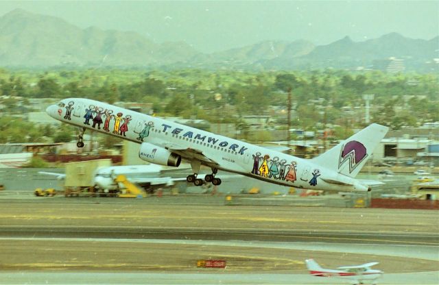 Boeing 757-200 (N902AW) - KPHX - America West 757 Logojet departing Phoenix in the very early Am. Photo date appx 1998 it was always nice to film at Phoenix as there was a wide variety of aircraft to capture and one could easily get many of the America West 757s painted in various schemes. Note the Honeywell 720 parked on their ramp in the background - this is the Boeing that had the smaller 5th jet engine attached on the side of the fuselage back then.