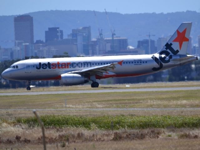 Airbus A320 (VH-VGN) - On taxi-way heading for Terminal 1, after landing on runway 23. City of Adelaide skyline appears in the background. Wednesday 4th January 2012.