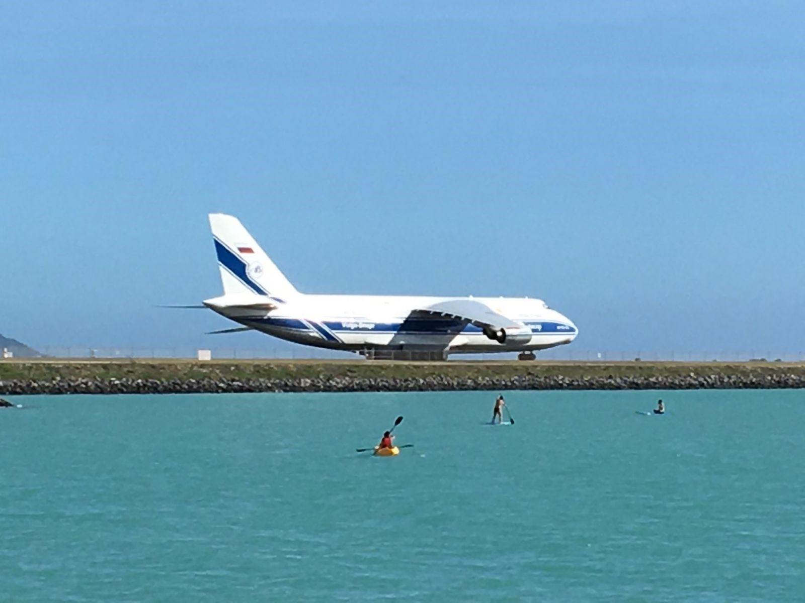 Antonov An-12 — - Photo taken 24 NOV 18 from Hickam Beach of an AN-124 (VDA1446) rolling to Runway 8R, departing HNL for GUM.