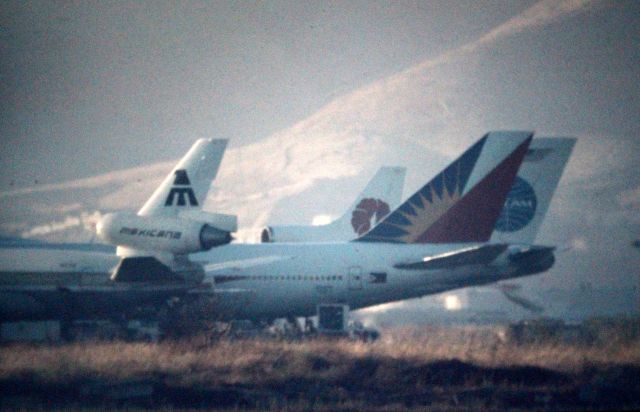 Boeing 747-200 — - SFO - long distance 1000mm lens shot of the old International dock area at SFO filmed from the now Bayside park area ( cept it wasn't a park then ) The old international dock is set to re-open Feb 2014. This photo date apprx Aug 1990