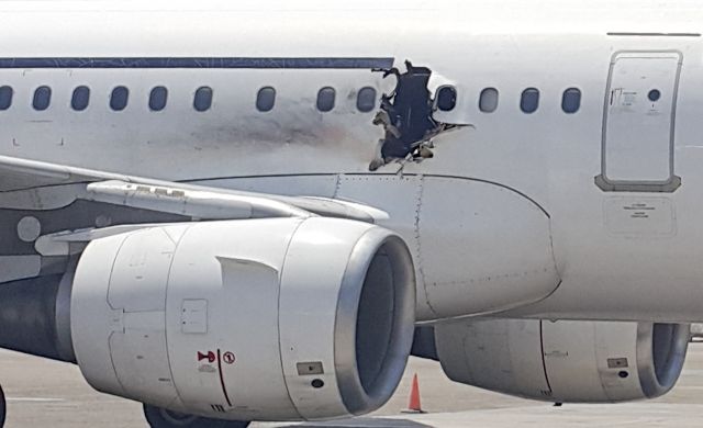 — — - In this Tuesday, February 2, 2016 photo, a hole is photographed in a plane operated by Daallo Airlines as it sits on the runway of the airport in Mogadishu, Somalia. A gaping hole in the commercial airliner forced it to make an emergency landing at Mogadishus international airport late Tuesday, officials and witnesses said. (Photo by AP Photo)
