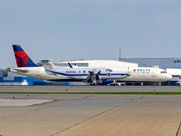 Pilatus PC-12 (N606NA) - Two for one… Here’s NASA606 rolling out on 24R with DAL1487, N110DX, an A321-211 on the takeoff roll bound for Hartsfield-Jackson Intl (KATL) on 24L, last night, 31 Jul 2024. Too bad the clouds blocked the sun on the PC-12.