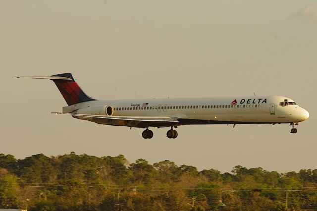 McDonnell Douglas MD-88 (N909DE) - Landing 25R, standing on top of the Embry-Riddle Maintenance Building.