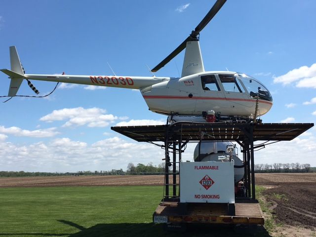 Robinson R-44 (N3203D) - Spraying fungicide on tomatoes early in the growing season to prevent frost damage