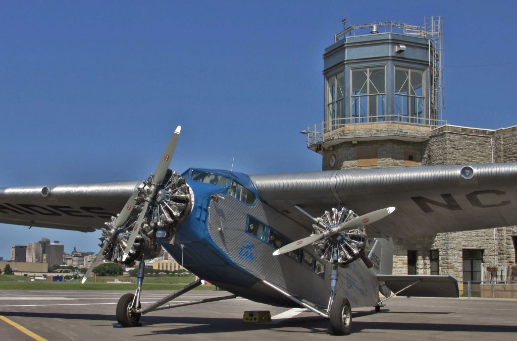 Ford Tri-Motor (N8407) - EAAs 1929 Ford Tri-Motor in front of the Downtown St Paul airport, "Holman Field"  administration building which was built by the WPA in 1939. 