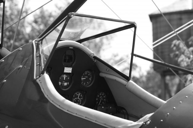 — — - The cockpit of a Stearman in front of the water tower at the Beaumont Hotel.  Photo by Michael Vincent