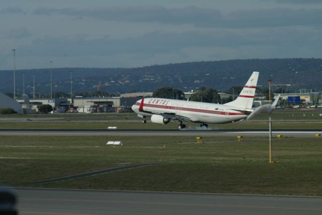 Boeing 737-800 (VH-VXQ) - Qantas Boeing 737-800 (Retro Roo 1959) smoking from rear tyres after landing on rwy 03 at Perth Intl Airport.