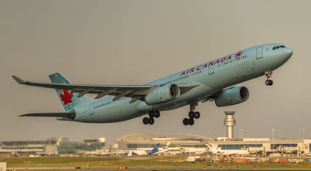 Airbus A330-300 (C-GFAH) - Sun illumines the airfield while this AC A330 lifts off runway 23 in the shade!