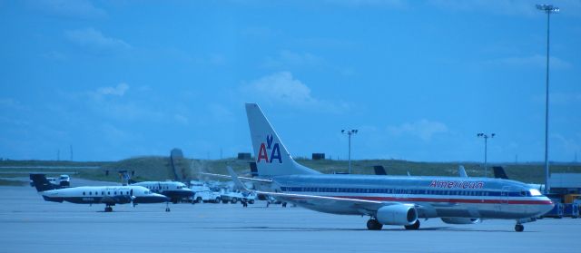 Boeing 737-800 (N891NN) - An American 737-800 and a Great Lakes Beech 1900 side-by-side outside concourse A.