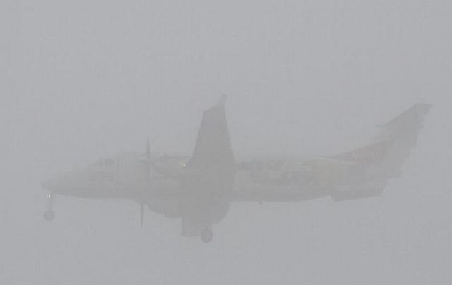 Beechcraft 1900 (N1900R) - Short final for runway 08 on this foggy morning.