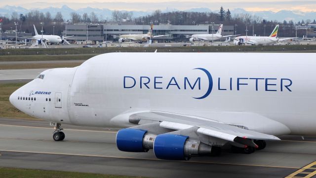 Boeing 747-400 (N718BA) - Dreamlifter taxiing to 16R for a delivery of 787 fuselage sections to KCHS.  Note Ethiads second 787-9 in the background at Boeings delivery center.