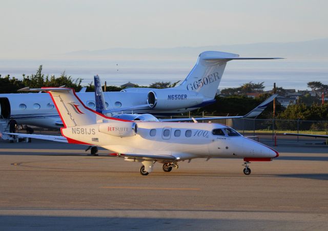 Embraer Phenom 100 (N581JS) - KMRY - N581JS sporting 100th titles, rolling to the main runway to depart - after dropping off passengers for the ATT Pro AM Golf at Pebble Beach.Feb 2015