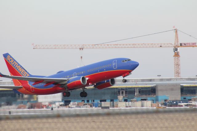 Boeing 737-700 (N938WN) - 030414 SWA rotating from Rwy 19R. The new Eisenhower terminal construction in the background