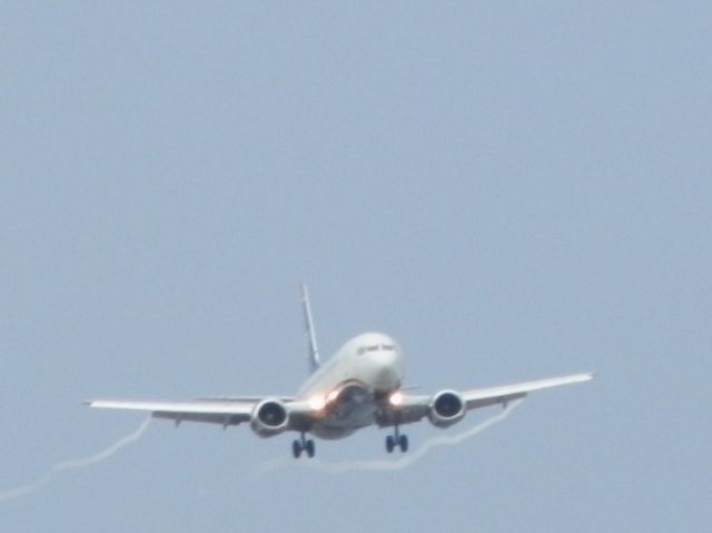 BOEING 737-400 (N452UW) - You see the wing vortexes.Form on a humid day!