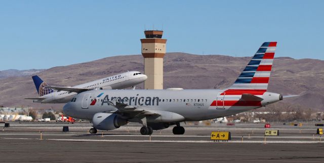 Airbus A319 (N704US) - American's N704US taxies north to the terminal as United's N454UA is on the climb away from 16R.