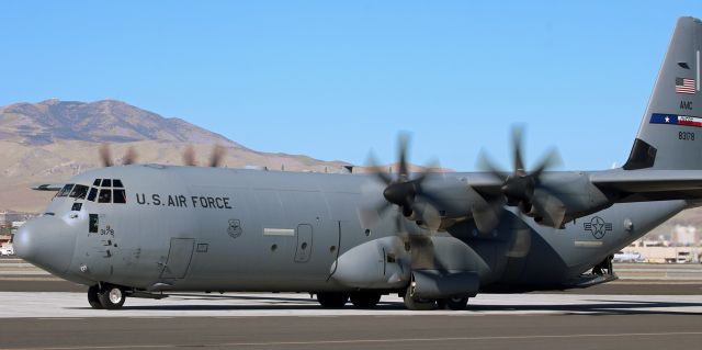 Lockheed C-130 Hercules (08-3178) - A crewman on the rear ramp watches me intently as the pilots of his Dyess-based C-130J begin to taxi their Hercules forward just after making a right turn while backing out of a parking spot among three small GA aircraft and two sibling 130Js on the Atlantic Aviation ramp.