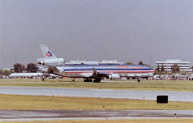 Boeing MD-11 (N1761R) - KSJC - American Airlines MD-11 going back to the gate after sitting for 20 minutes at 30L hold pad. This was common in the early 1990s deliveries of the MD-11, they'd push back, taxi to the hold bars and sit. This Tokyo Narita bound Airliner would depart about 2 hours later. I only had 1-hr lunch and had to sckedattle. CN 48551 LN 527.