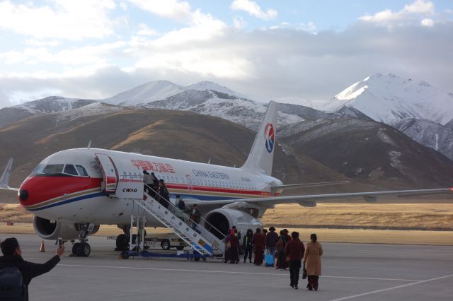 Airbus A319 (B-6446) - Passengers board against the Yushus backdrop of soaring mountains